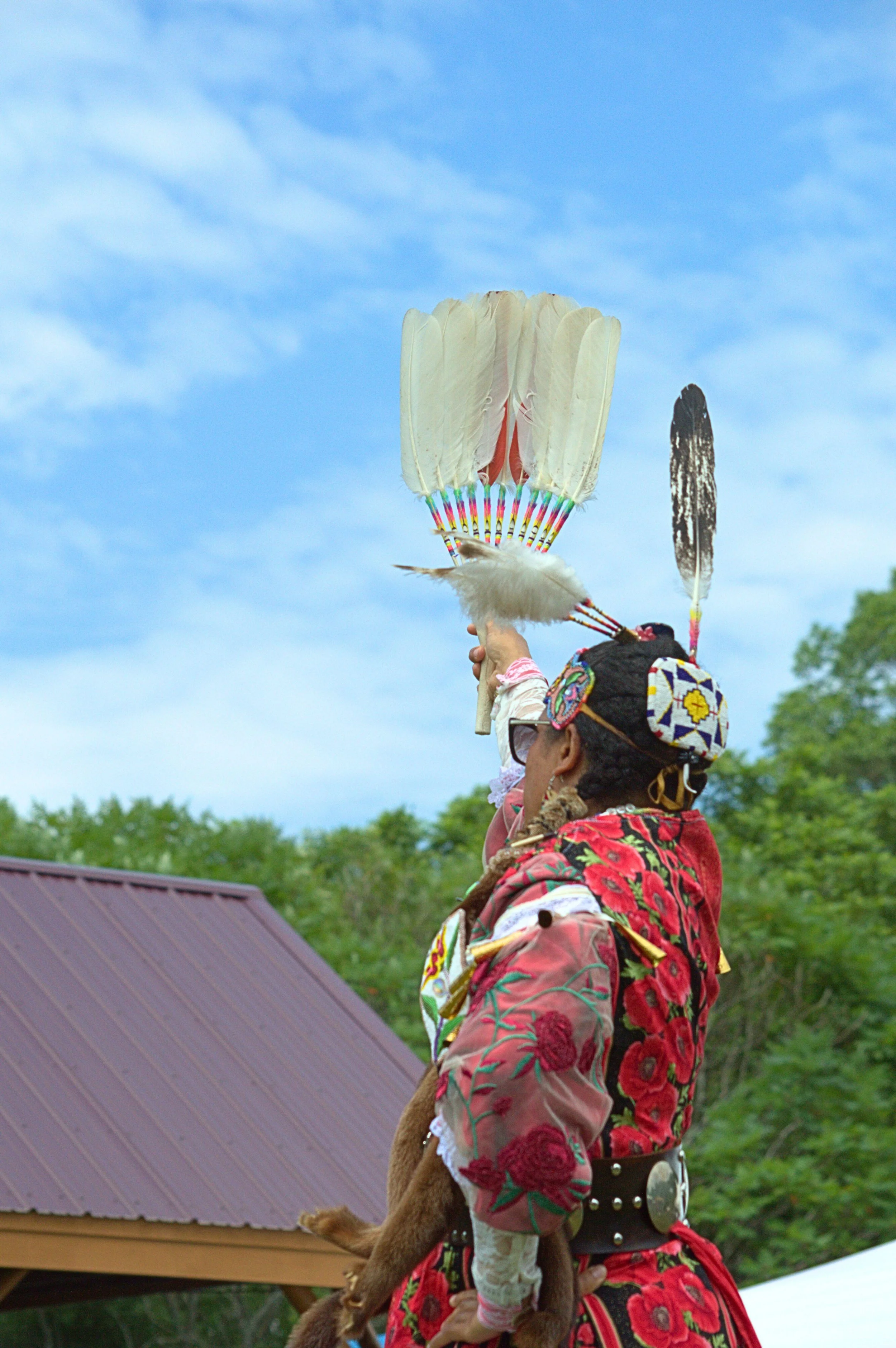Native powwow dancer holding her dance fan at family friendly summer event in Central NH at Mt Kearsarge Indian Museum