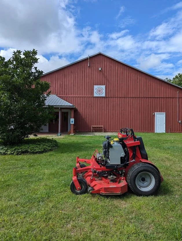 Lawn mower in front of Mt. Kearsarge Indian Museum representing volunteer groundskeeping and community support