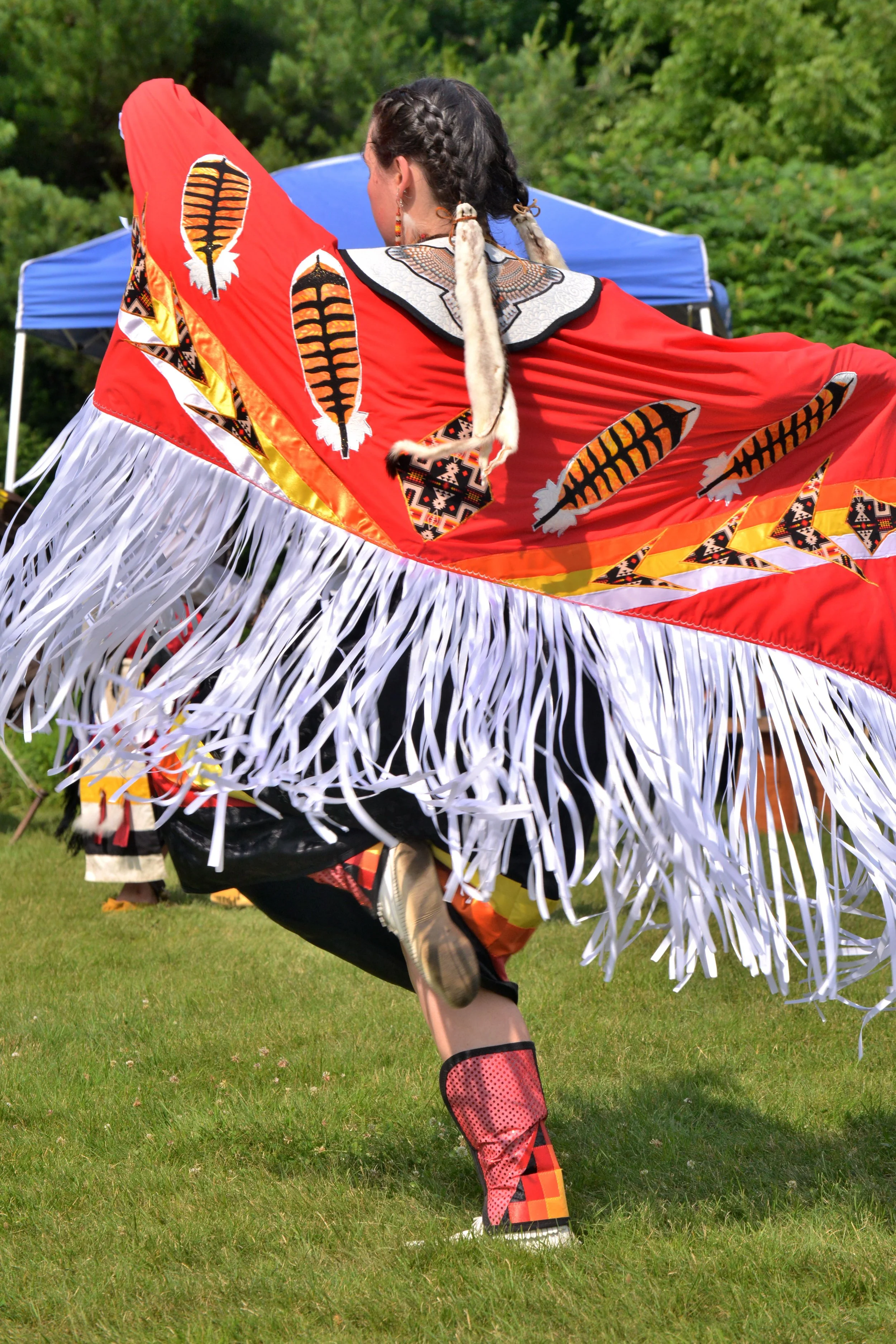 Female powwow dancer in traditional regalia during a cultural celebration