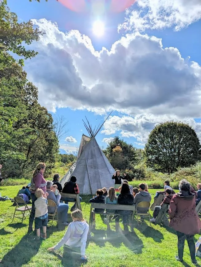 Group of adults and children participating in an outdoor educational program at Mt. Kearsarge Indian Museum, NH