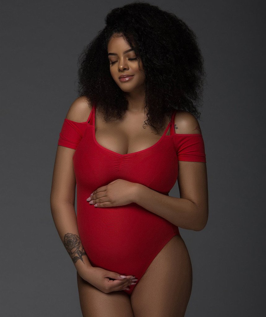 Chicago pregnant woman wearing red body suit for a photoshoot
