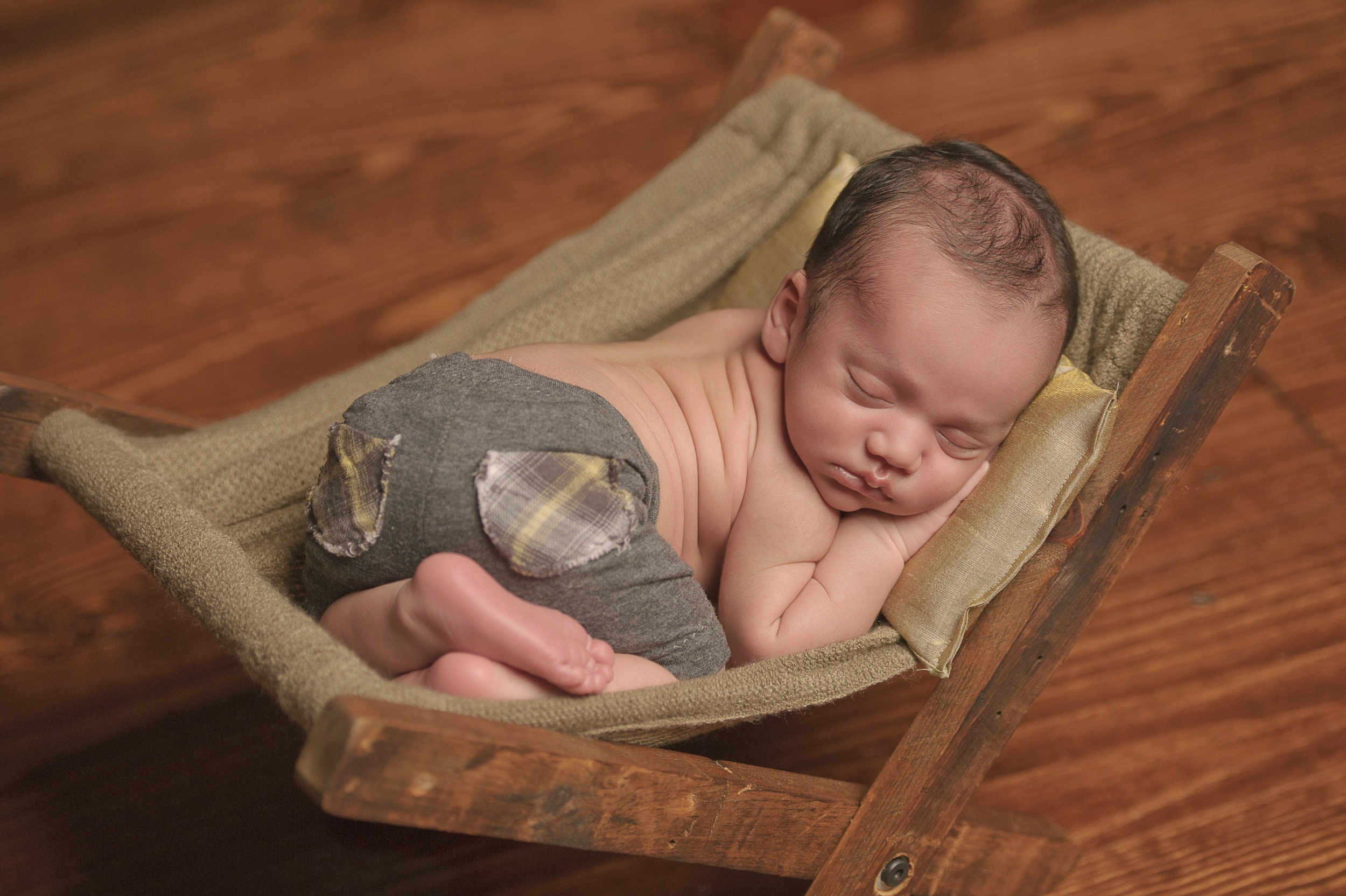 Newborn baby posed in an adorable sleeping position