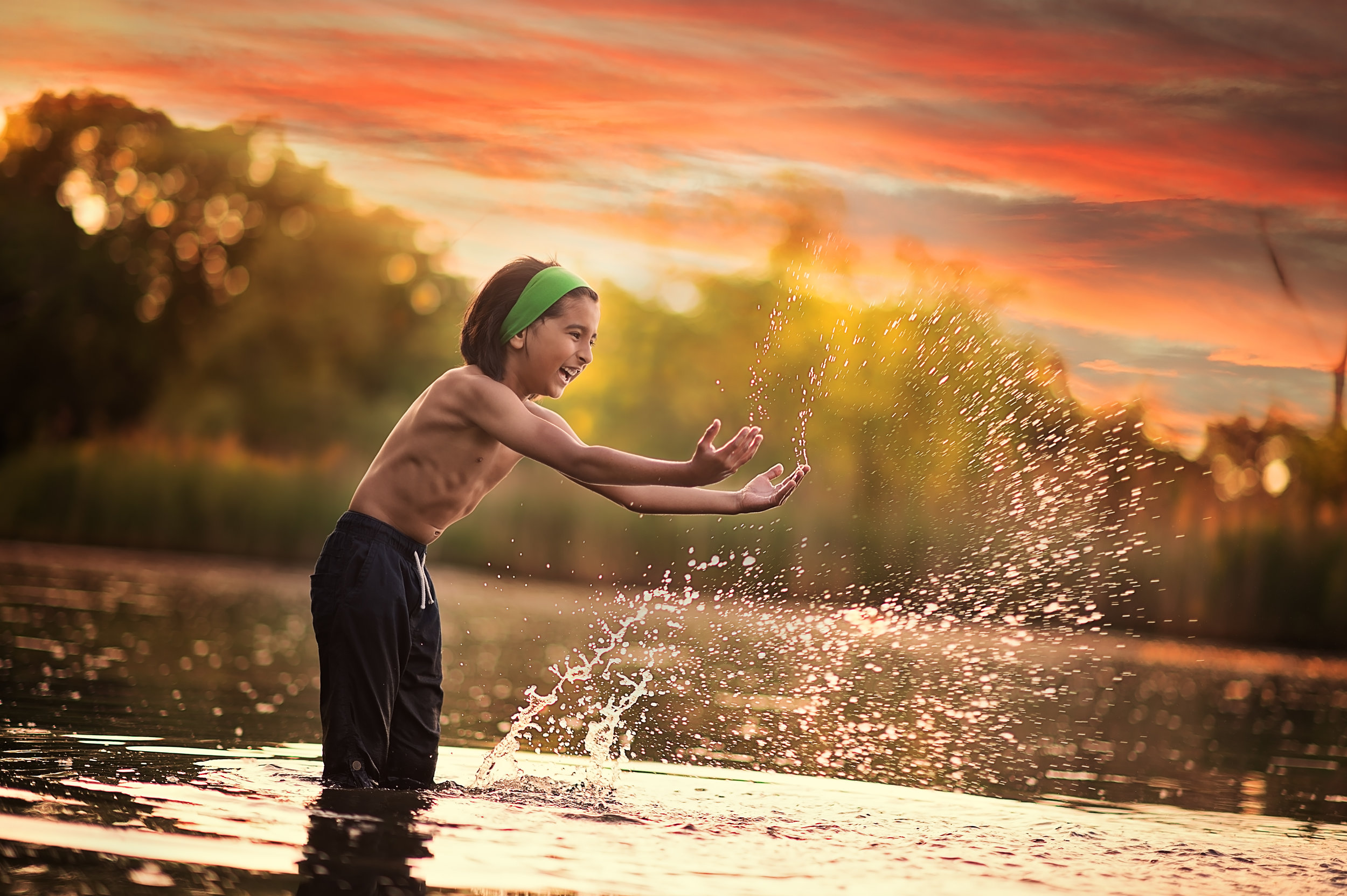 Boy enjoying an outdoor photoshoot in water by Sri and Jana Photography