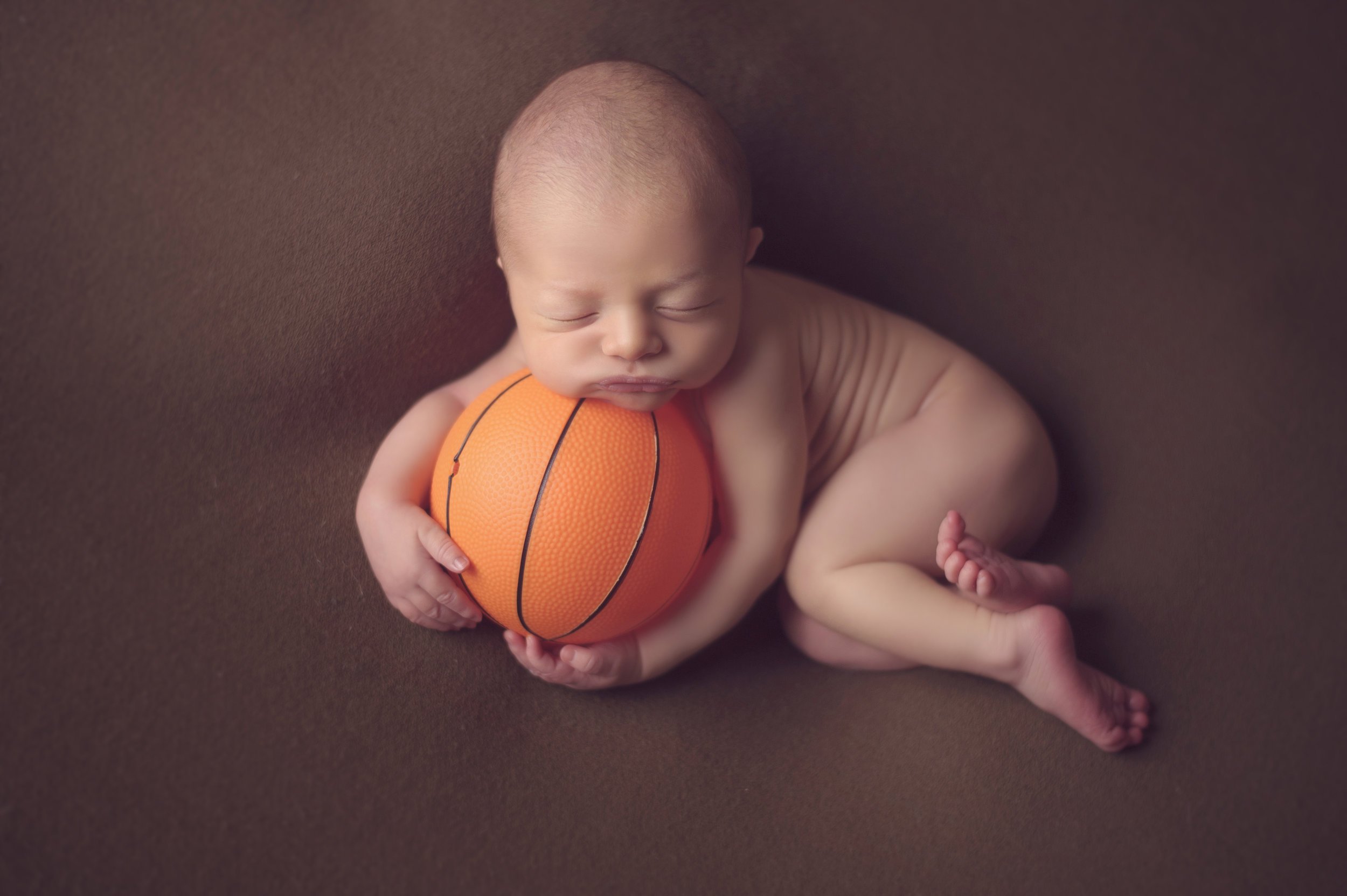 Newborn baby surrounded by soft plush toy