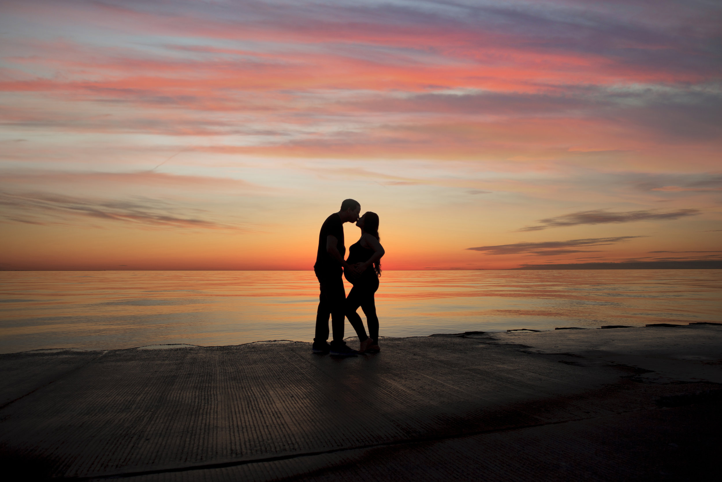 Couple maternity photoshoot at the sea edge