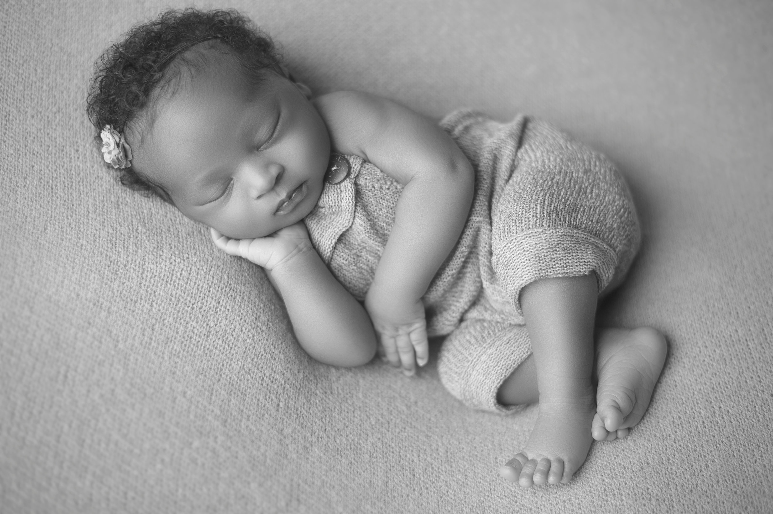 Newborn baby posed in an adorable sleeping position