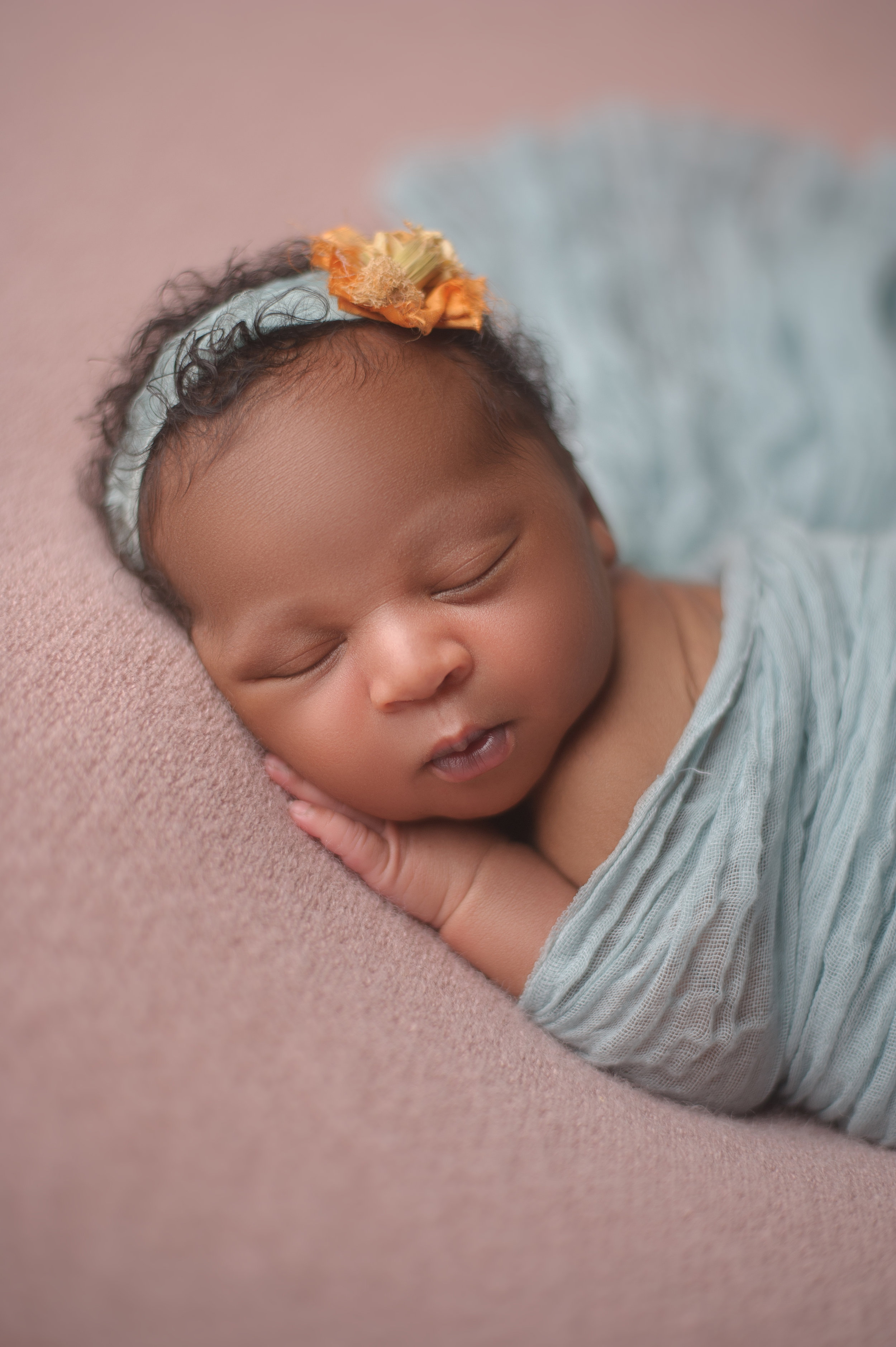 Newborn baby posed in an adorable sleeping position