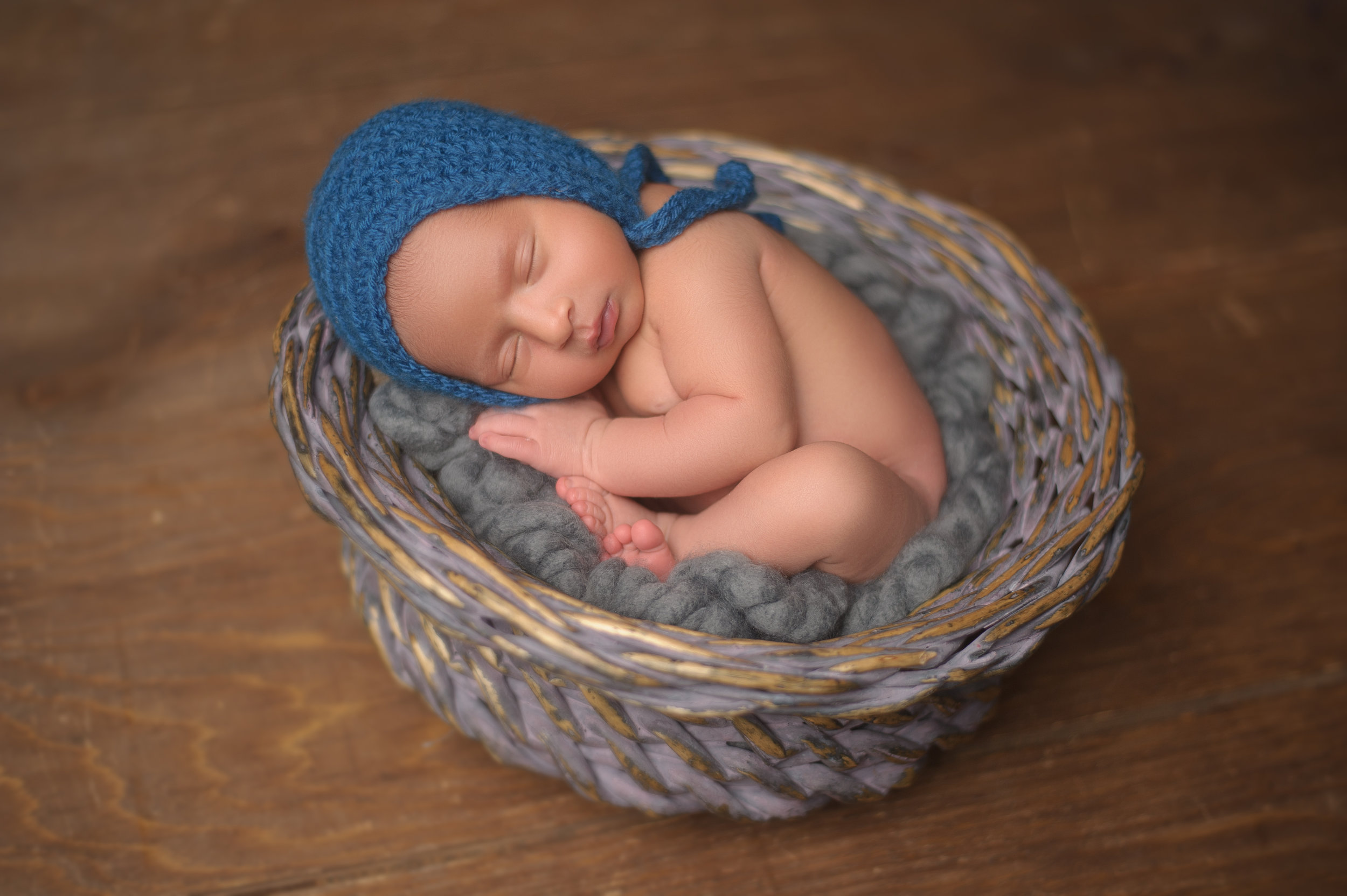 Newborn baby posed in an adorable sleeping position