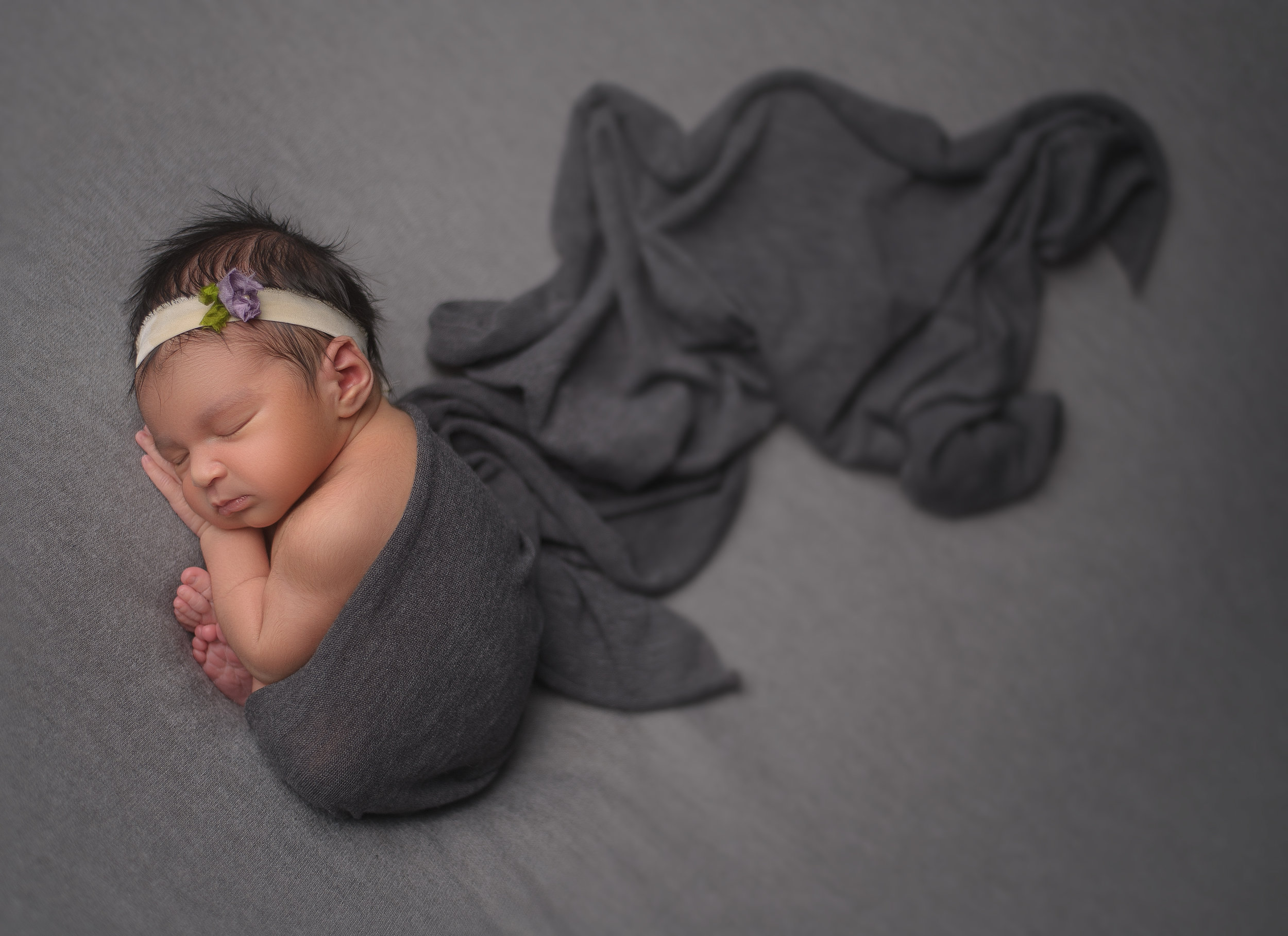 Newborn baby posed in a sweet embrace