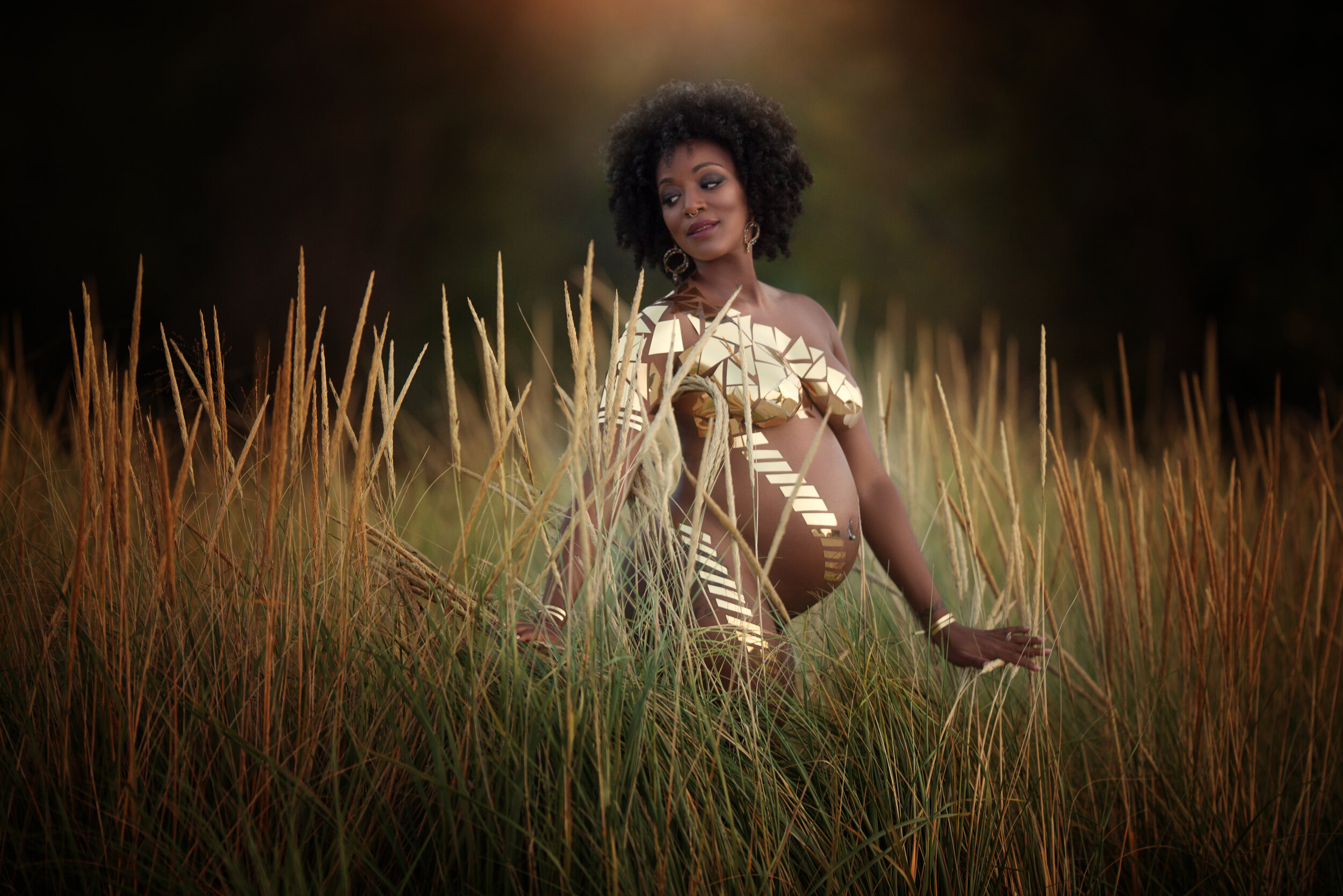 Pregnant woman in brown dress posing in grass