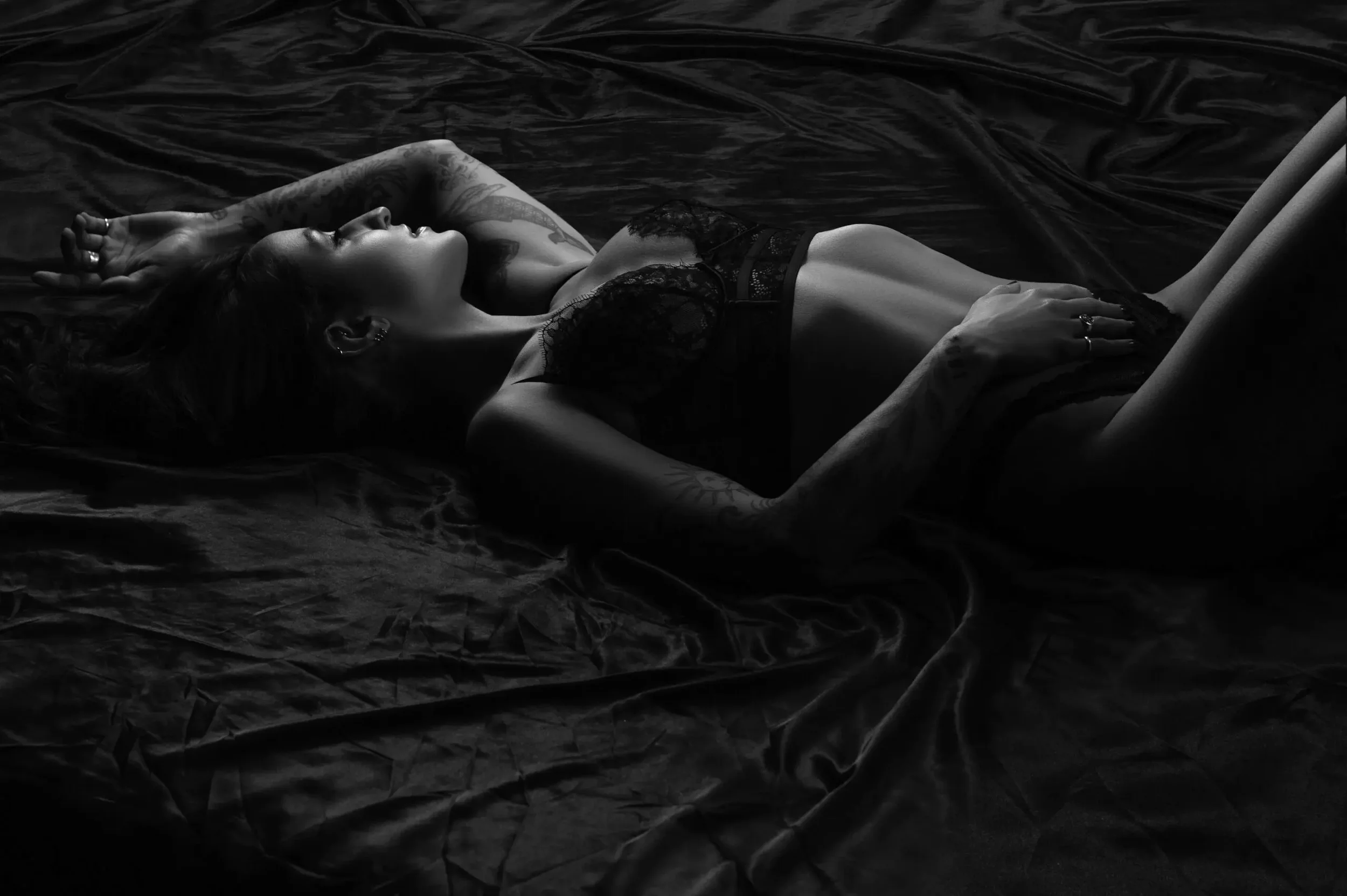 chicago-boudoir-photography-black-white-tattoos-lace-sheets.webp