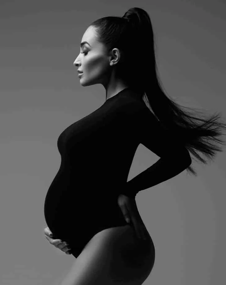 Best maternity photographers in Chicago: Pregnant lady in a black bodysuit in maternity photography studio