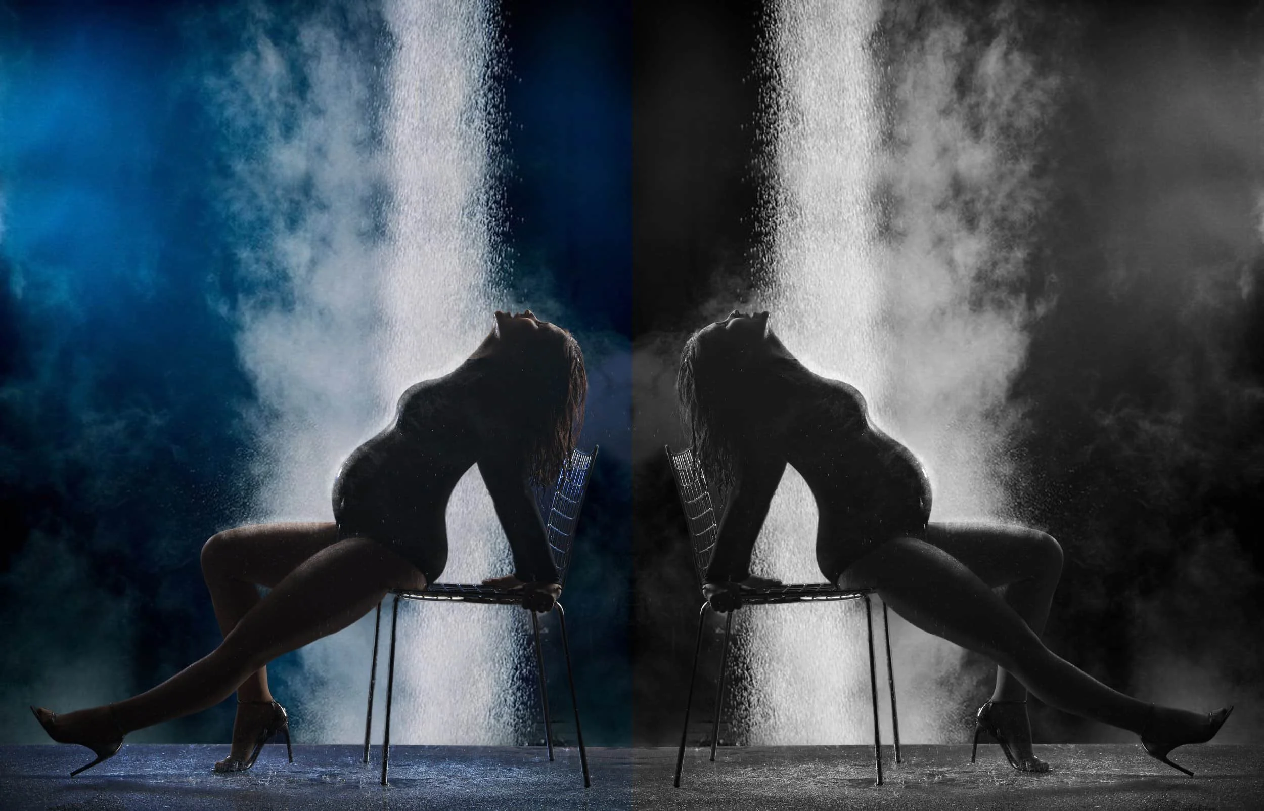 A person sitting on a chair with their back arched and head tilted backward, with water falling from above onto their face, creating a symmetrical, artistic scene with a mirrored effect.