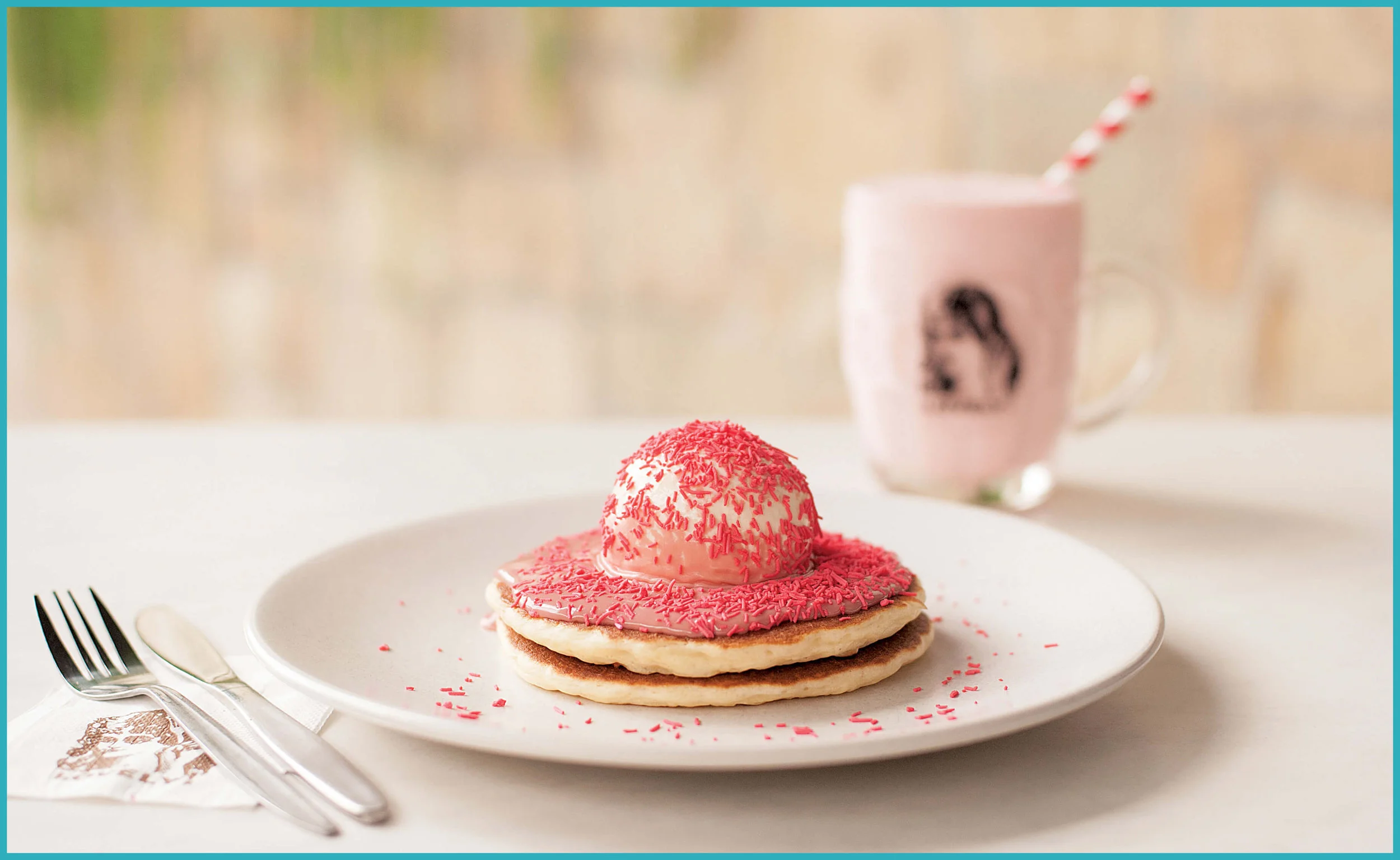 Two buttermilk pancakes topped with ice-cream and ruby chocolate fudge, and sprinkled with hundreds and thousands.