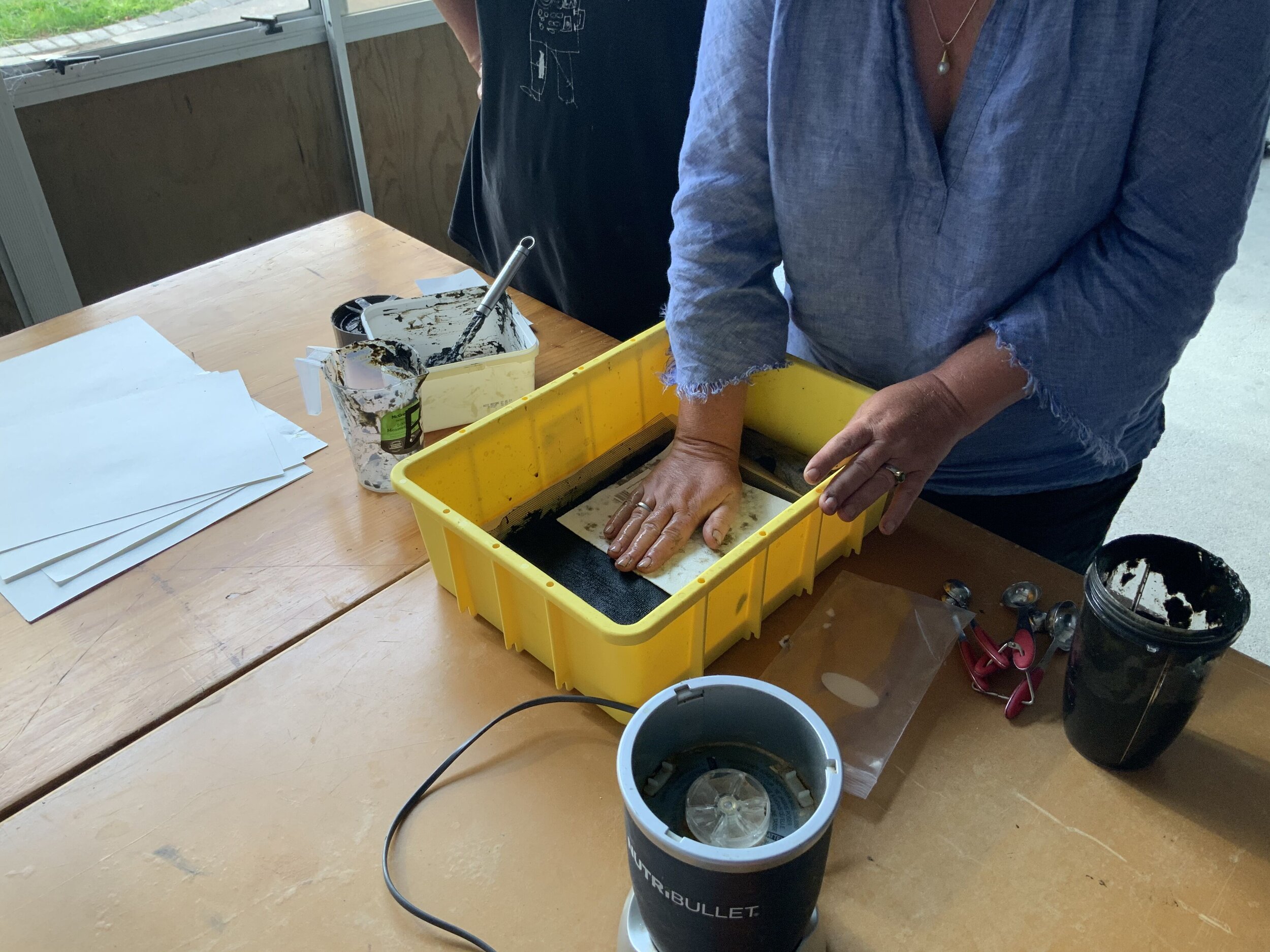 Maria pressing the water from hornwort mixture to make paper