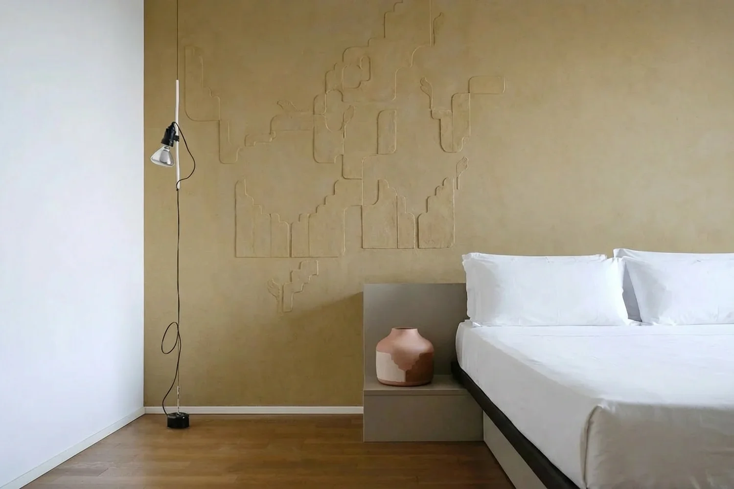  Facing a large terrace for the exclusive use of the room-guests, the  Junior Suite  presents a large, bright and nicely furnished room with wood flooring and a dedicated work space. The wall with a high relief in raw clay that characterises this roo
