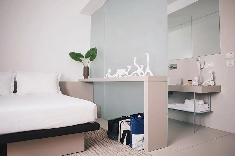  Also available with separate beds, this double room stands out for its elegance and comfort. An opal glass panel separates the bedroom from the bathroom, with its shower and washbasin, allowing natural light to spread and reflections to multiply. 