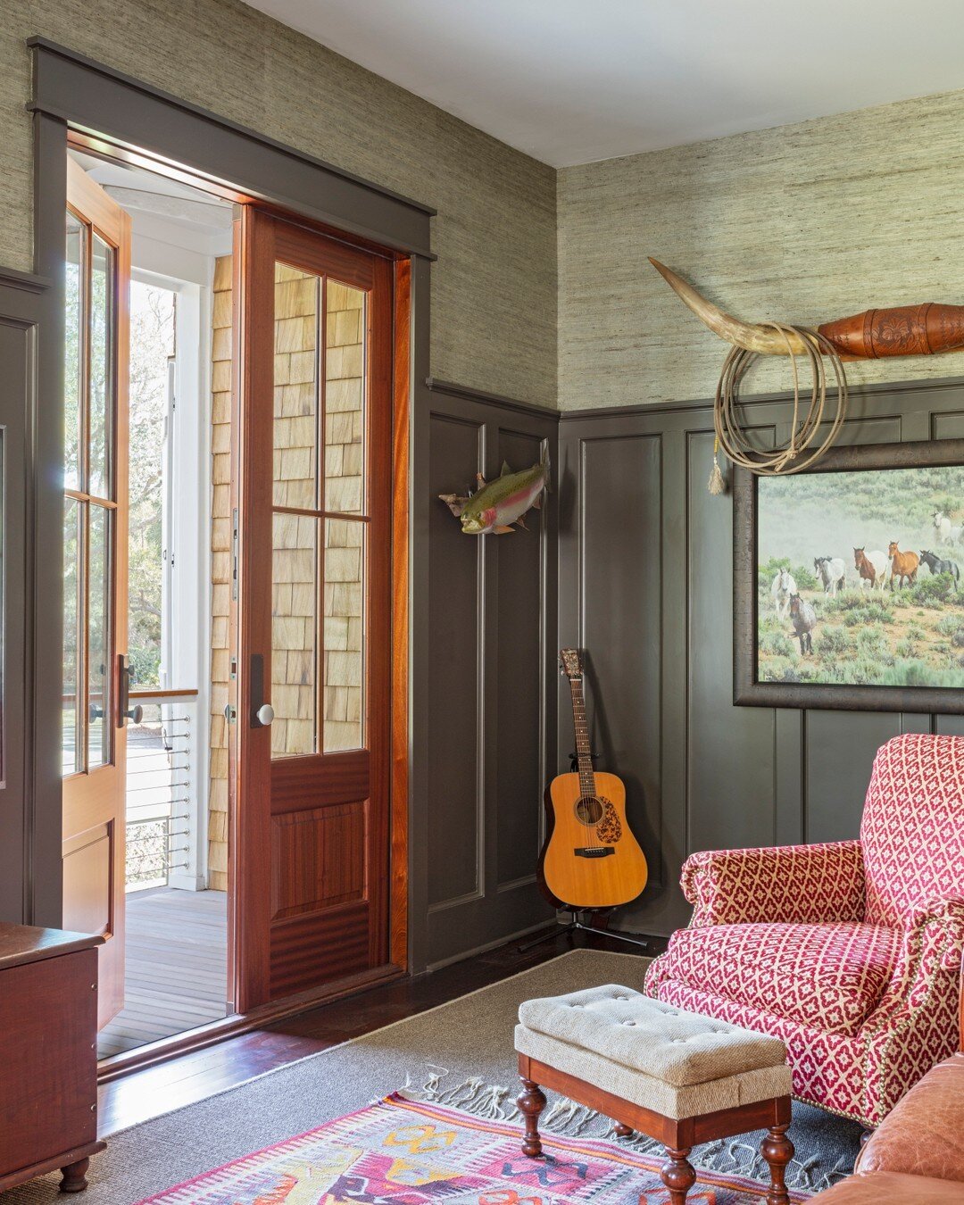 A cozy den opens up to a large piazza with cedar-shake siding.​​​​​​​​​.
Photography: @julialynnphotography
.
.
.
#beachhouse #customhome #cedarshake #darkpaneling #den #carpentry #custom #interiors #architecture