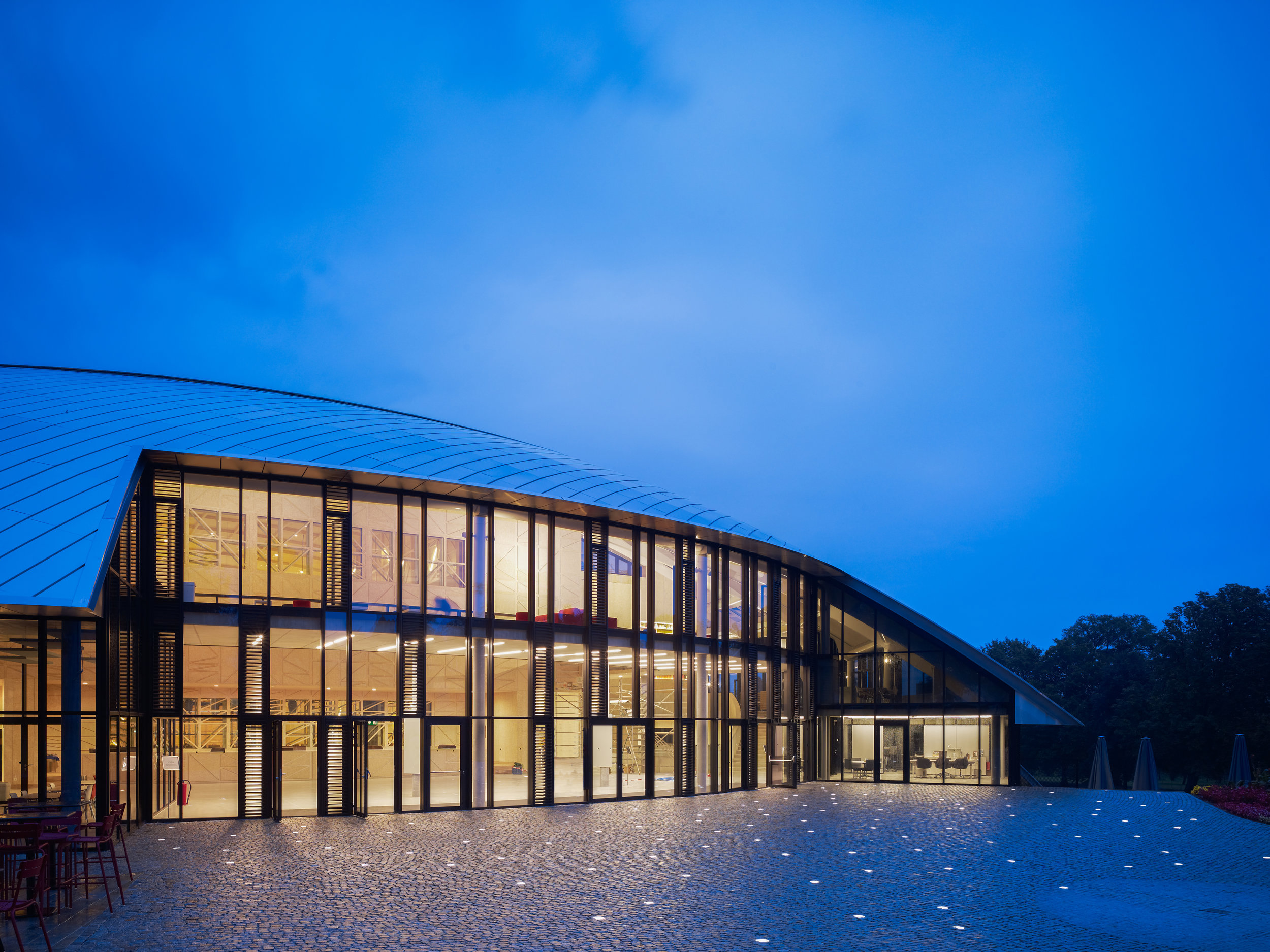 The entrance is framed by cuts in the low-lying dome. Exterior facades continue inside as glazed handrails. (Photo: Christian Richters)