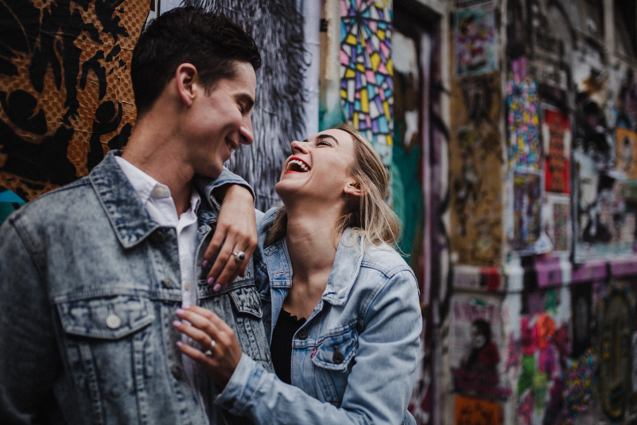 Couple laughing together during their Brick Lane engagement shoot.