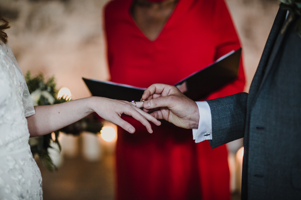 Groom places a ring on his brides finger during the ceremony.