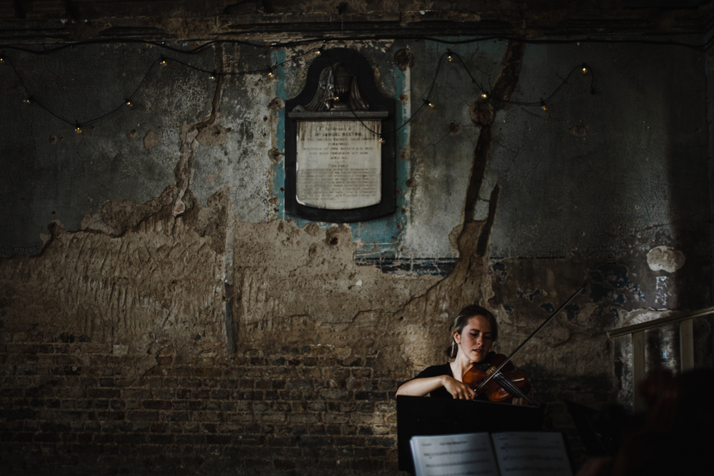 A Violinist plays background music as the couple sign the marriage register.