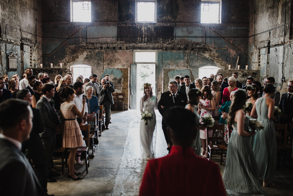 Bride and her dad walk down the aisle to meet the groom at the Asylum Chapel.