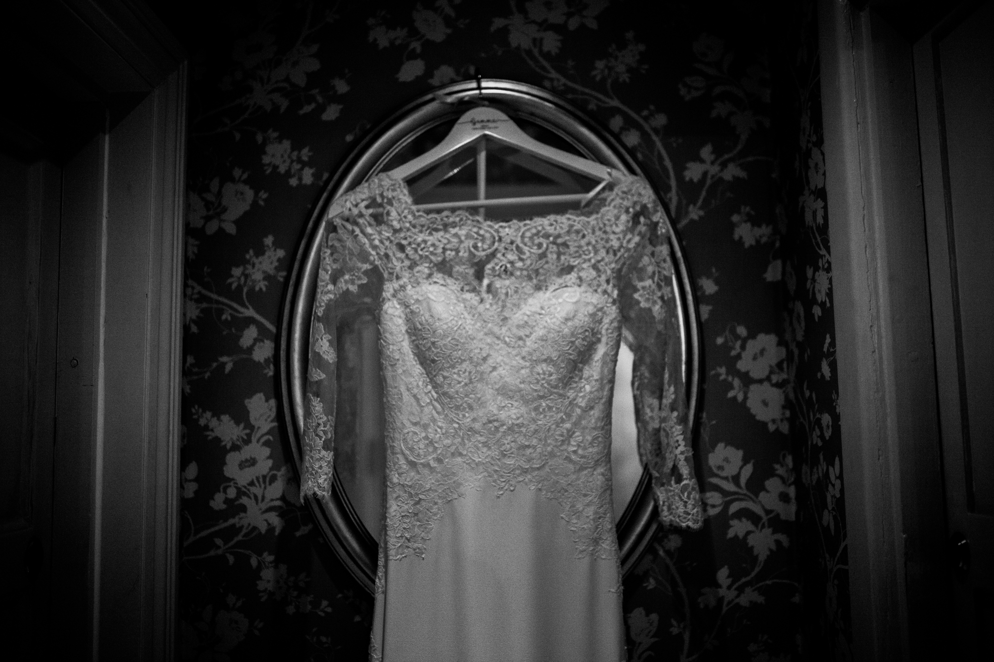 Mirror in hallway with wedding dress hanging on it