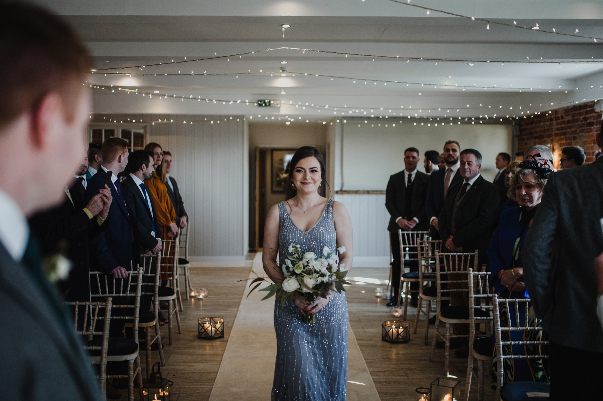 Bridesmaid walking down the aisle at Sopley Mill wedding venue