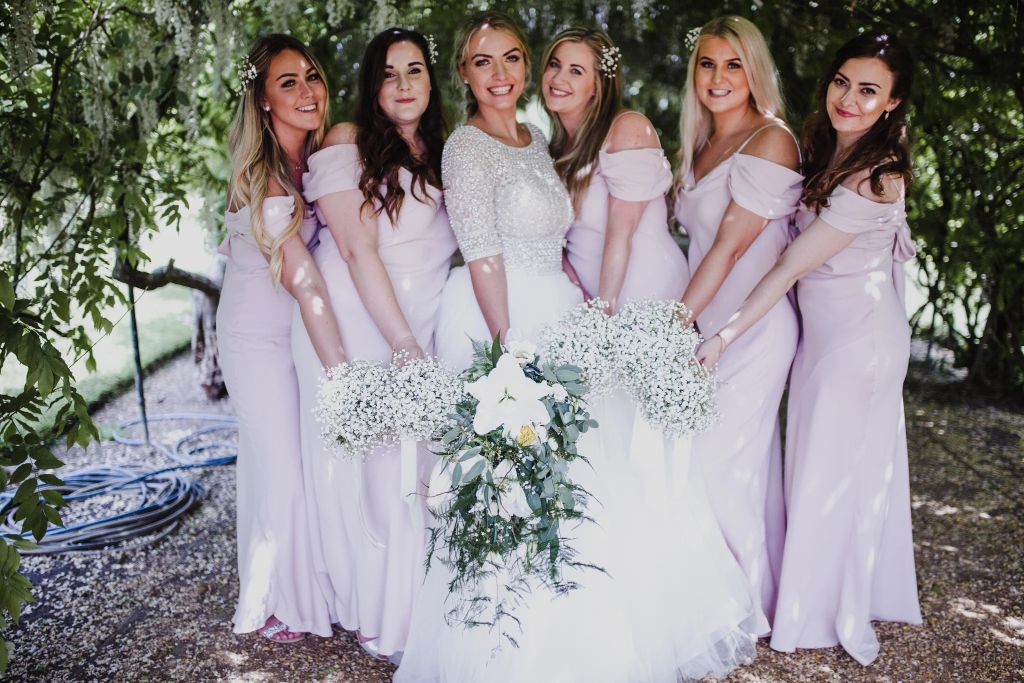 Bridesmaids holding bouquets together and smiling