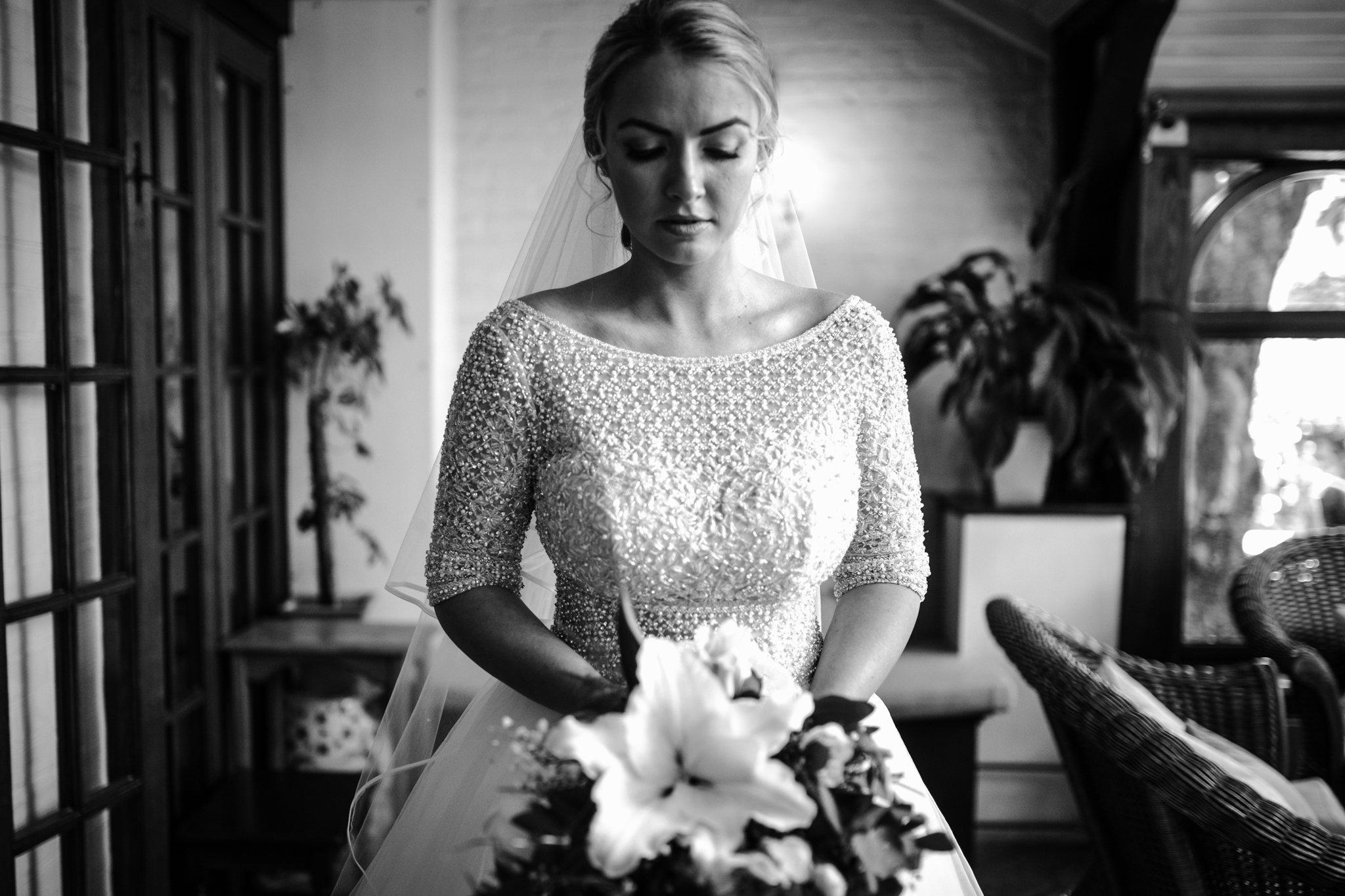 A black and white portrait of a bride and her flowers before the wedding