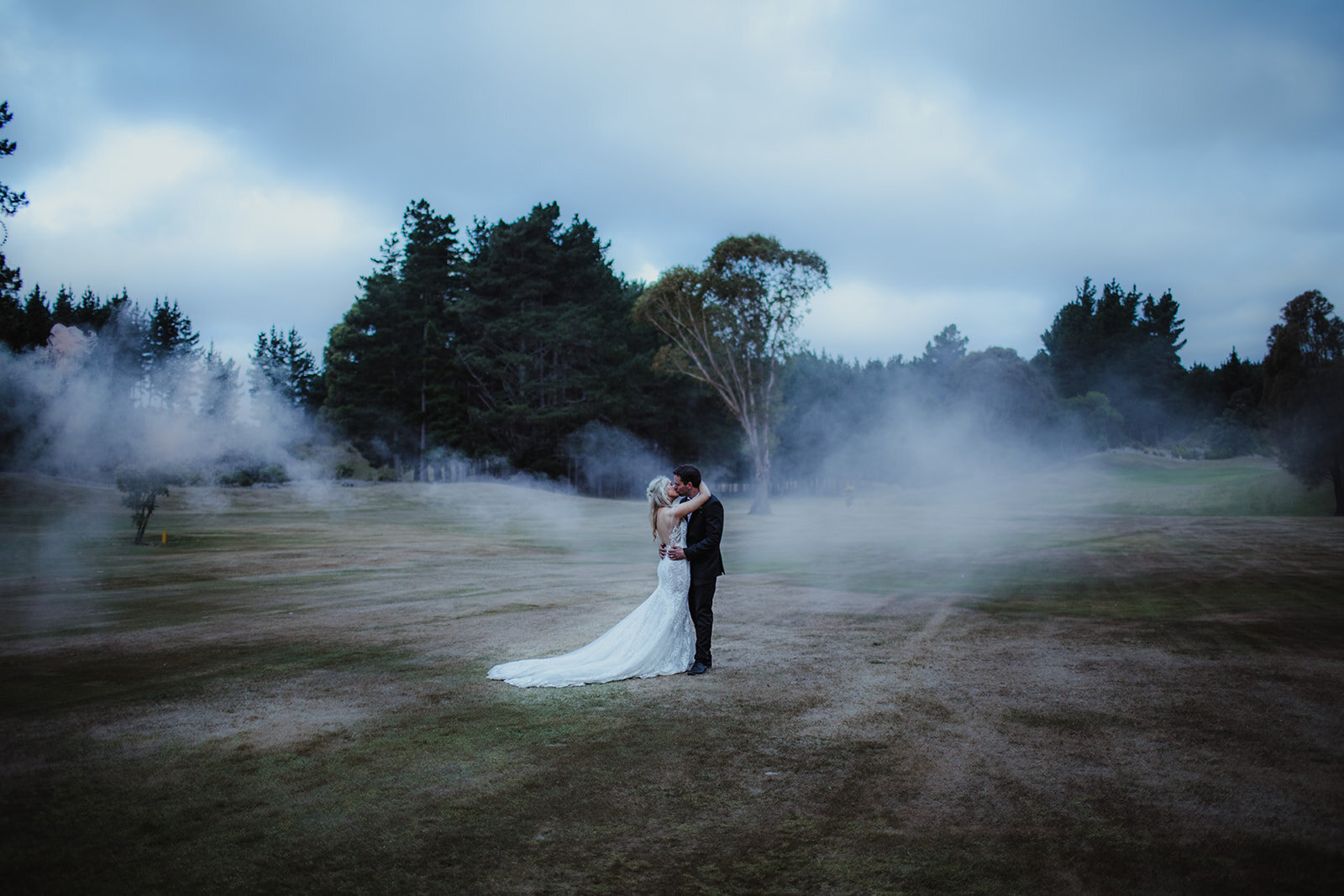 Couple portrait with smoke bombs at a back garden wedding