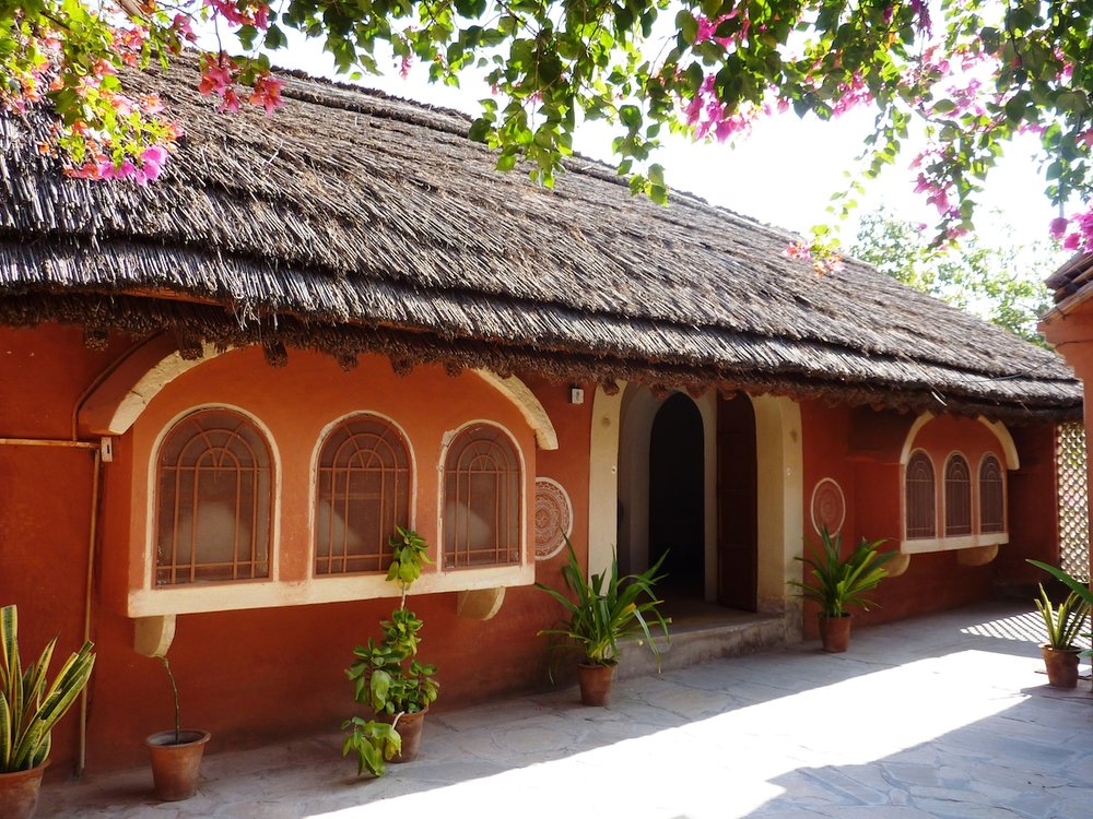 A traditional mud and grass thatched bungalow at Apani Dhani keeps the interior naturally cool in the hot desert climate.