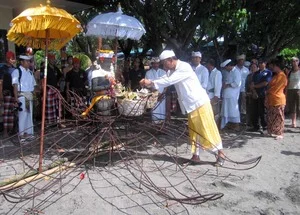 Pak Prana blesses the Coral Goddess in a Balinese ceremony before she is carried to rest under the sea