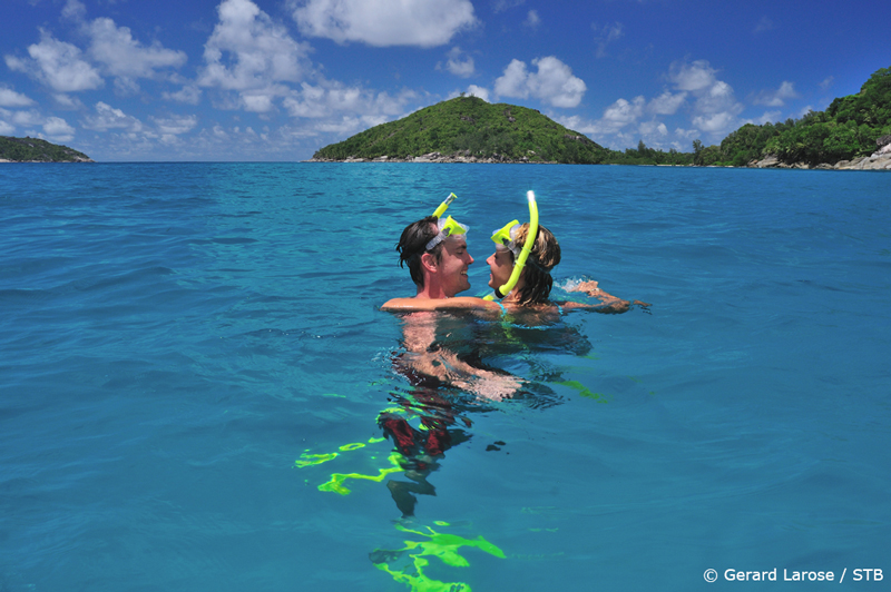 A couple snorkelling at Port Launay; Seychelles is a popular destination for honeymooners.