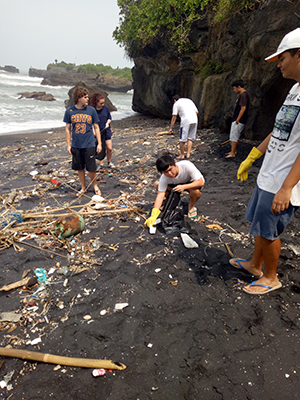 Joe, Josh, Delaney and Pablo from Canggu Community School gathering rubbish. Plastic and naturally degrading driftwood mix together in an unattractive spill on the sand
