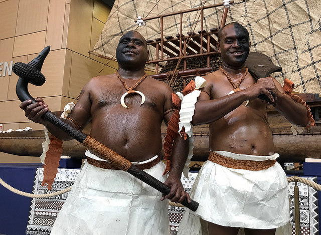 Fijians striking a pose in front of the drua display, an ocean Fijian canoe, at the UN Climate Change Conference in Bonn, to symbolise sailing with collective determination for the success of COP23.
