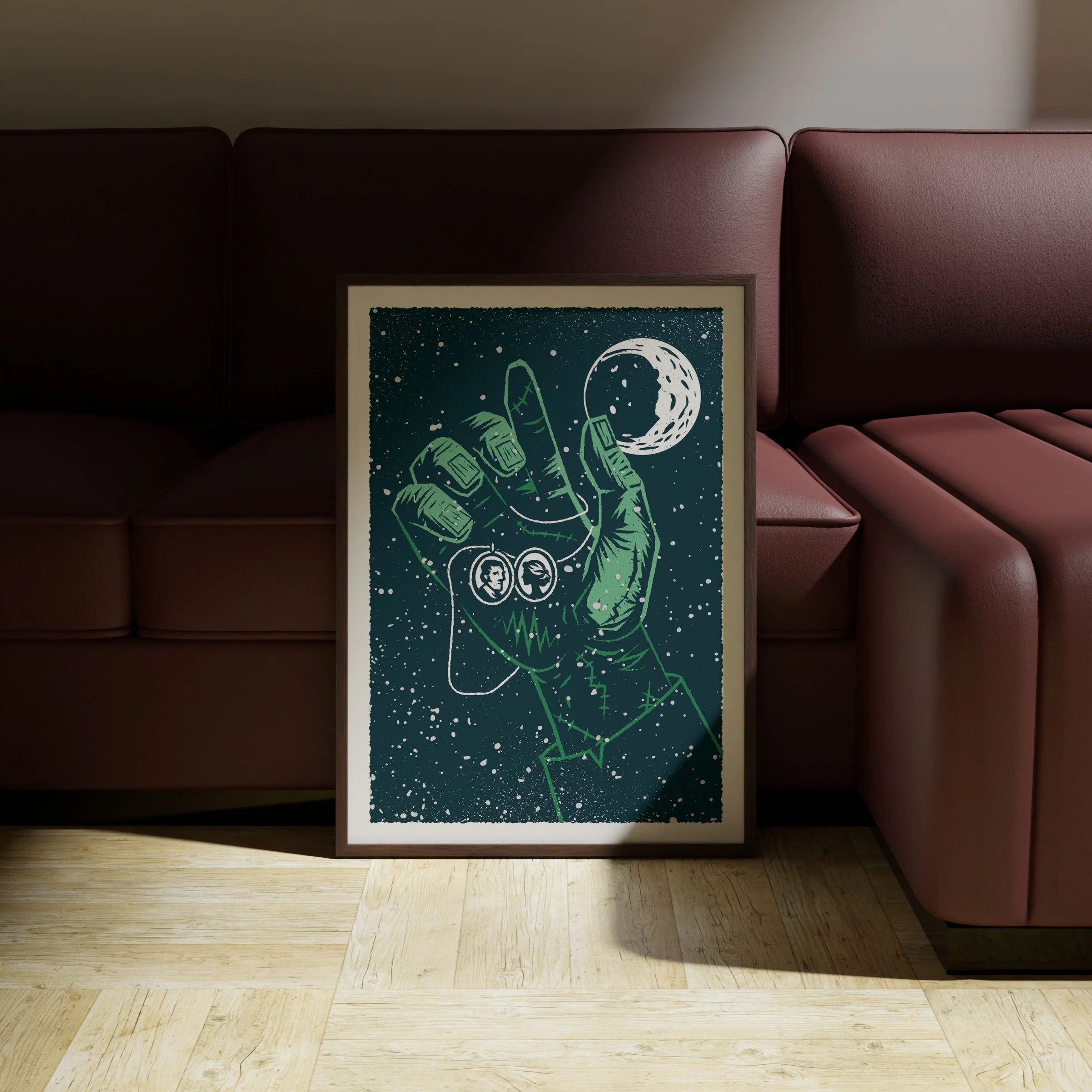 The Spark - Frankenstein Art Print, shown in a dark frame above a warm sofa. Print supplied unframed.