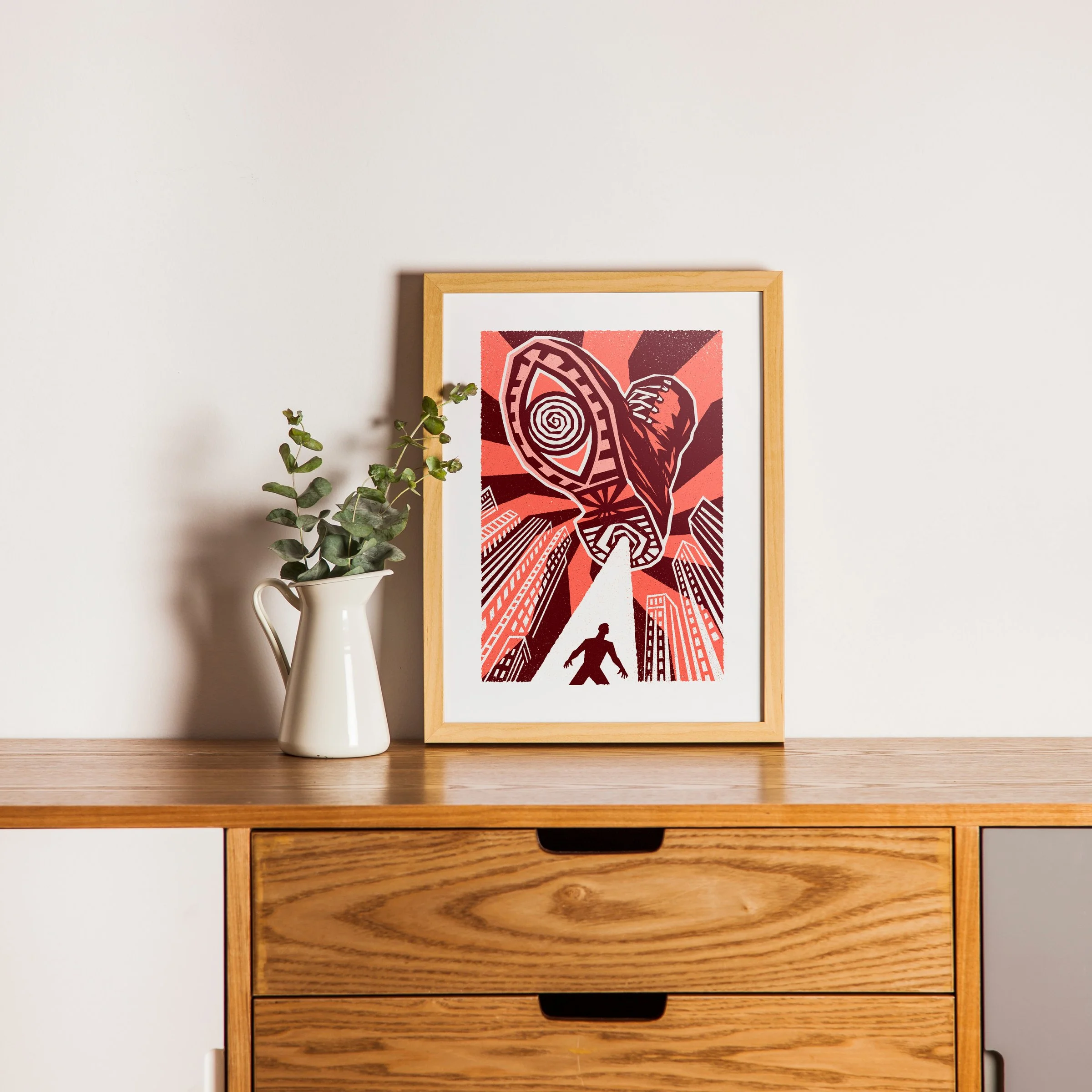 He’s Watching - Watchful Eye Art Print, shown in a oak frame above an oak cabinet. Print supplied unframed.