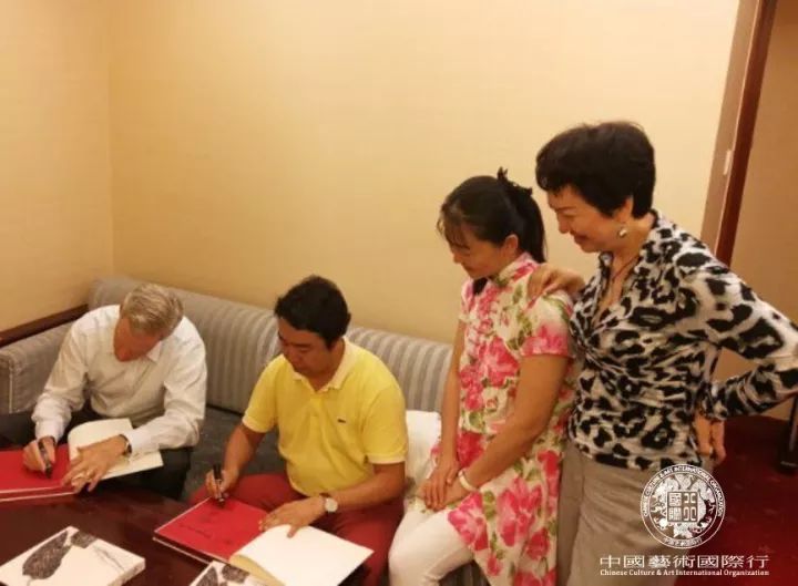 斯蒂文先生与刘中先生在合作的《相约在夏季》作品集上签字