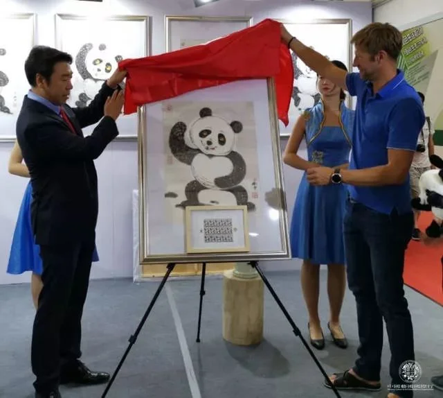 刘中(左)与马尔代夫邮政官员为“太极熊猫”邮票揭幕