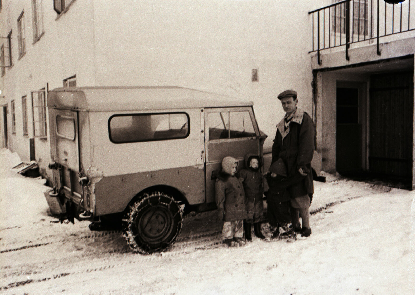 Morfar foran sykehusgarasjen sammen med Tove og Nina og et tredje barn.