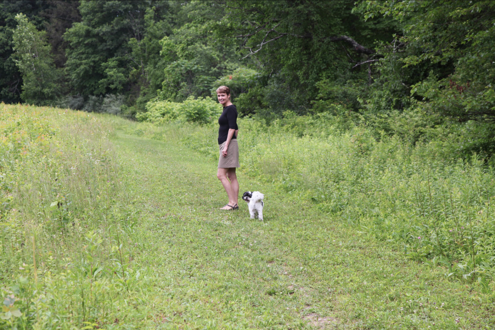 Mary Beth, with her Shih Tzu Bushwick, walks a trail across the lane from her upstate New York home.