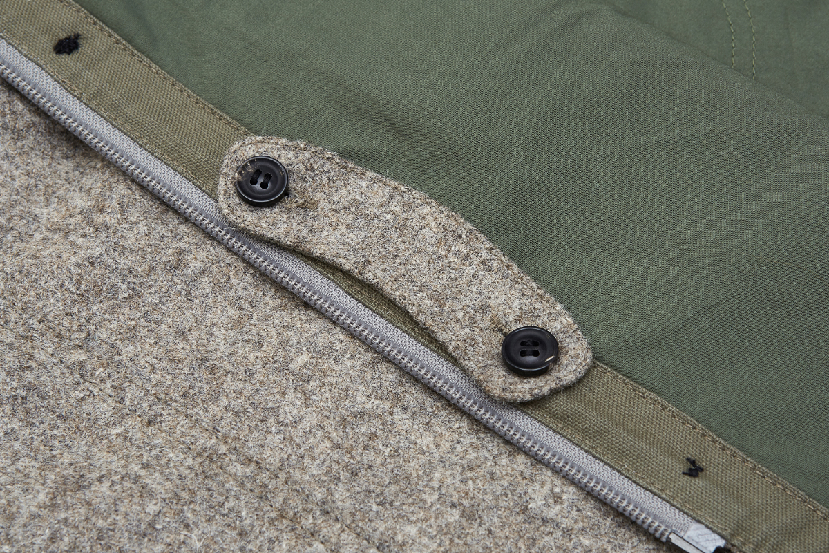 When not needed, tab can be stowed on the inside of placket.