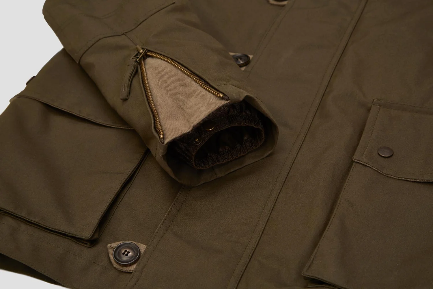 Cuff gusset and storm guard stop elements entering sleeve.