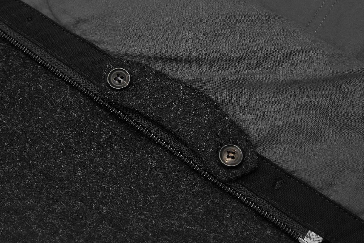 When not needed, tab can be stowed on the inside of placket.