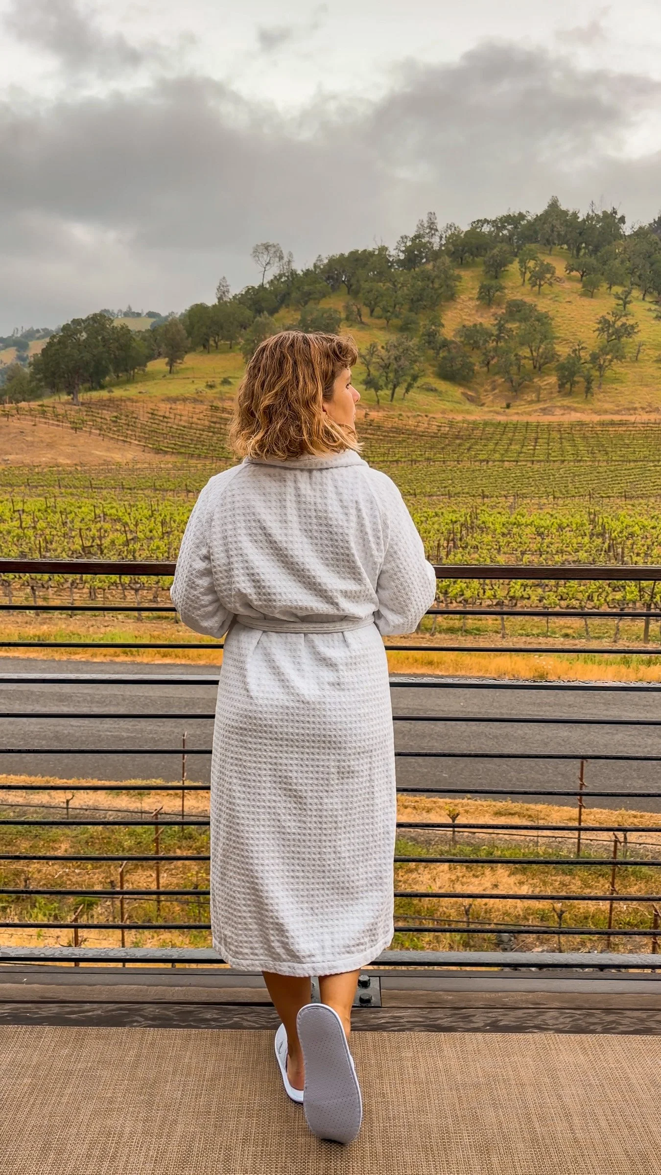 Woman standing on balcony in bathrobe at Four Seasons Napa