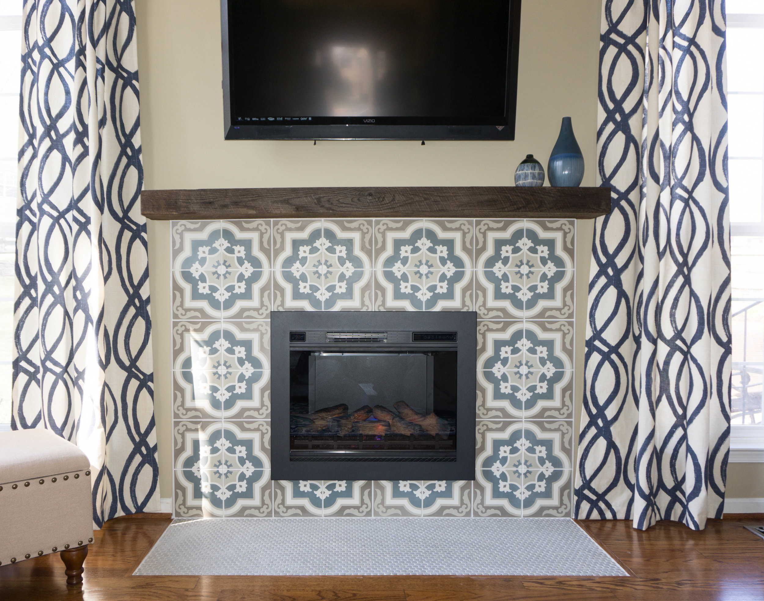  Their builder grade fireplace was updated in the mosts fab way with this new tile surround and reclaimed wood beam mantle. 