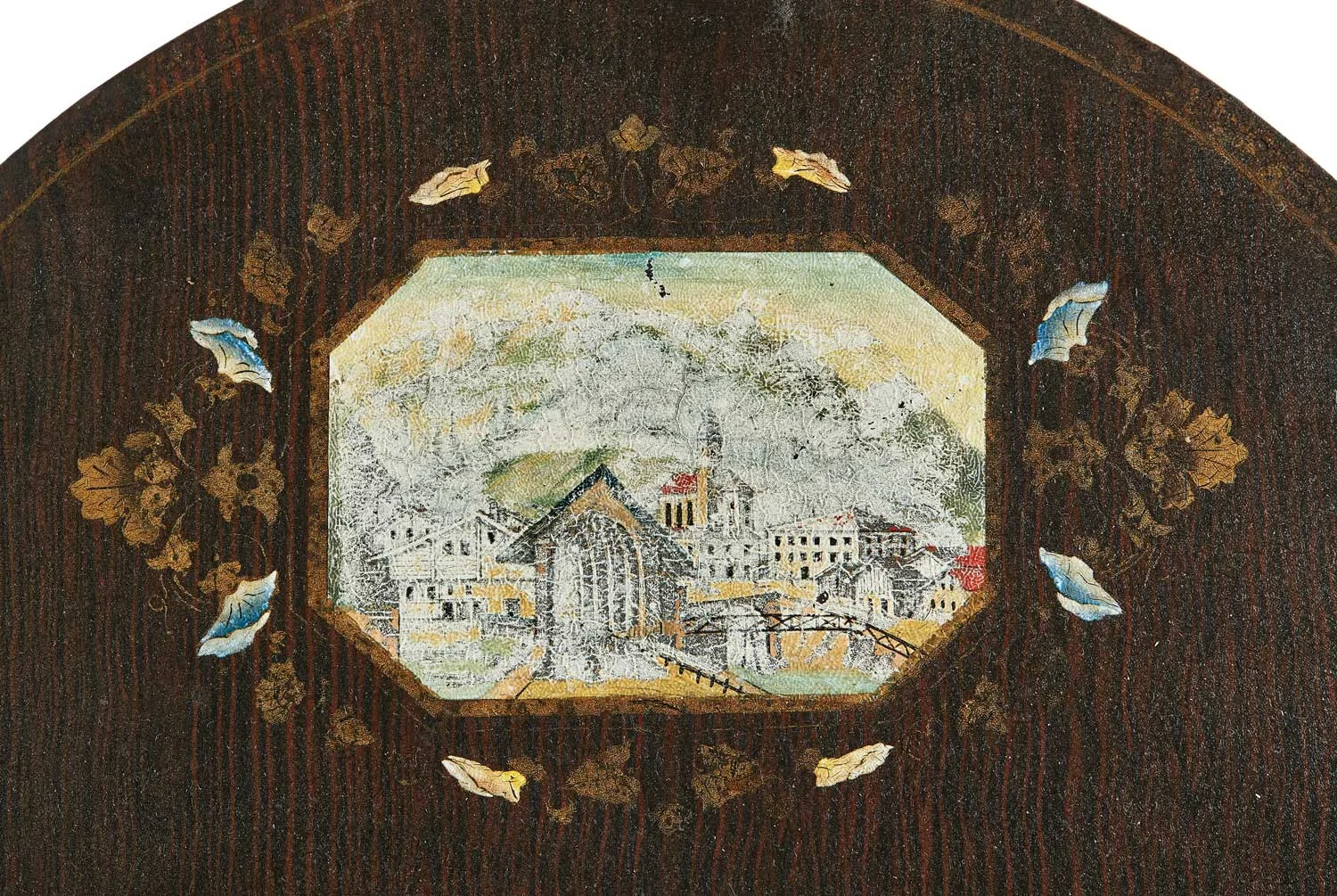 This Mandtler clock face is particularly uusual. It is painted a deep brown and has detailing that appears to imitate a wood grain. While this was a technique sometimes used on traditional Mennonite furniture, it was not commonly used on clocks. It also features a city scene, either real or imagined, in the arch where most Mennonite wall clocks focused on floral or nature scenes.
