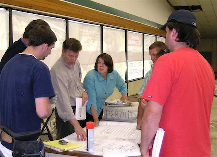 Tyler Myers, Myers Group President, and Christine Hurley, Executive Director of Goosefoot in 2009, go over blueprints for the store's renovation.